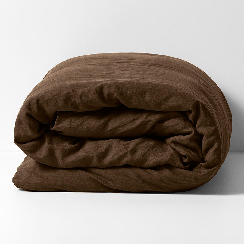 Emile linen quilt cover in Chocolate styled on a bed