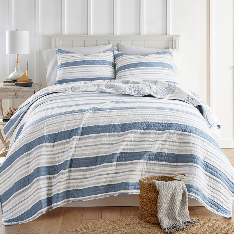 Spring bed layered with a coverlet, lightweight bedding and blanket